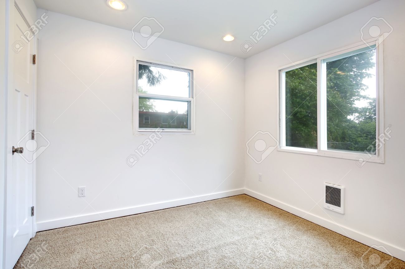 Lege kleine kamer met twee ramen, witte muren en beige ...