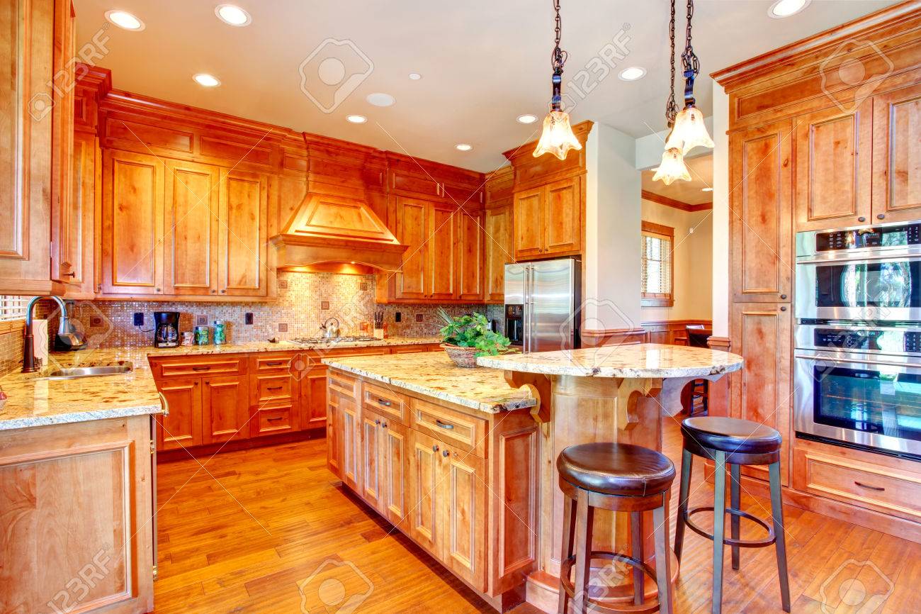 Beautiful kitchen with gold cabinets and steel appliances tile ...