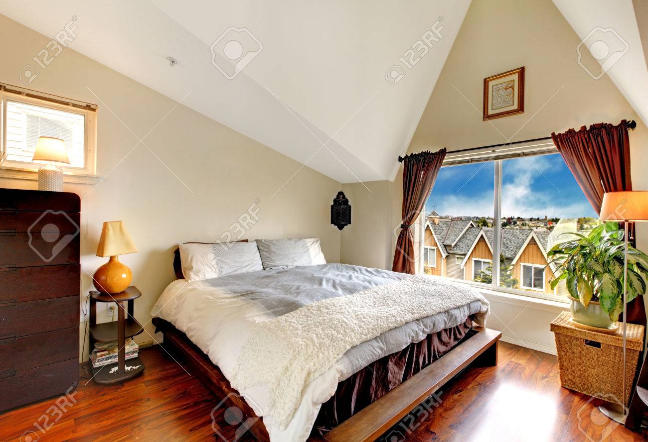 Mooie slaapkamer met gewelfd plafond, hardhouten vloer en raam ...