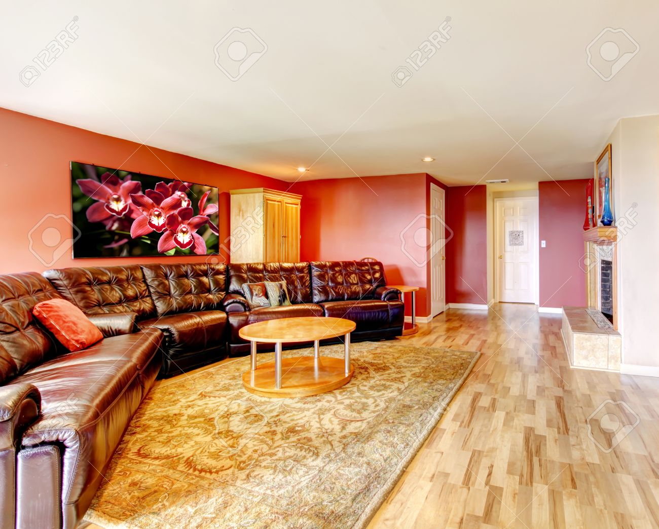 Woonkamer met heldere rode muur, lichtbruin hardhouten vloer ...