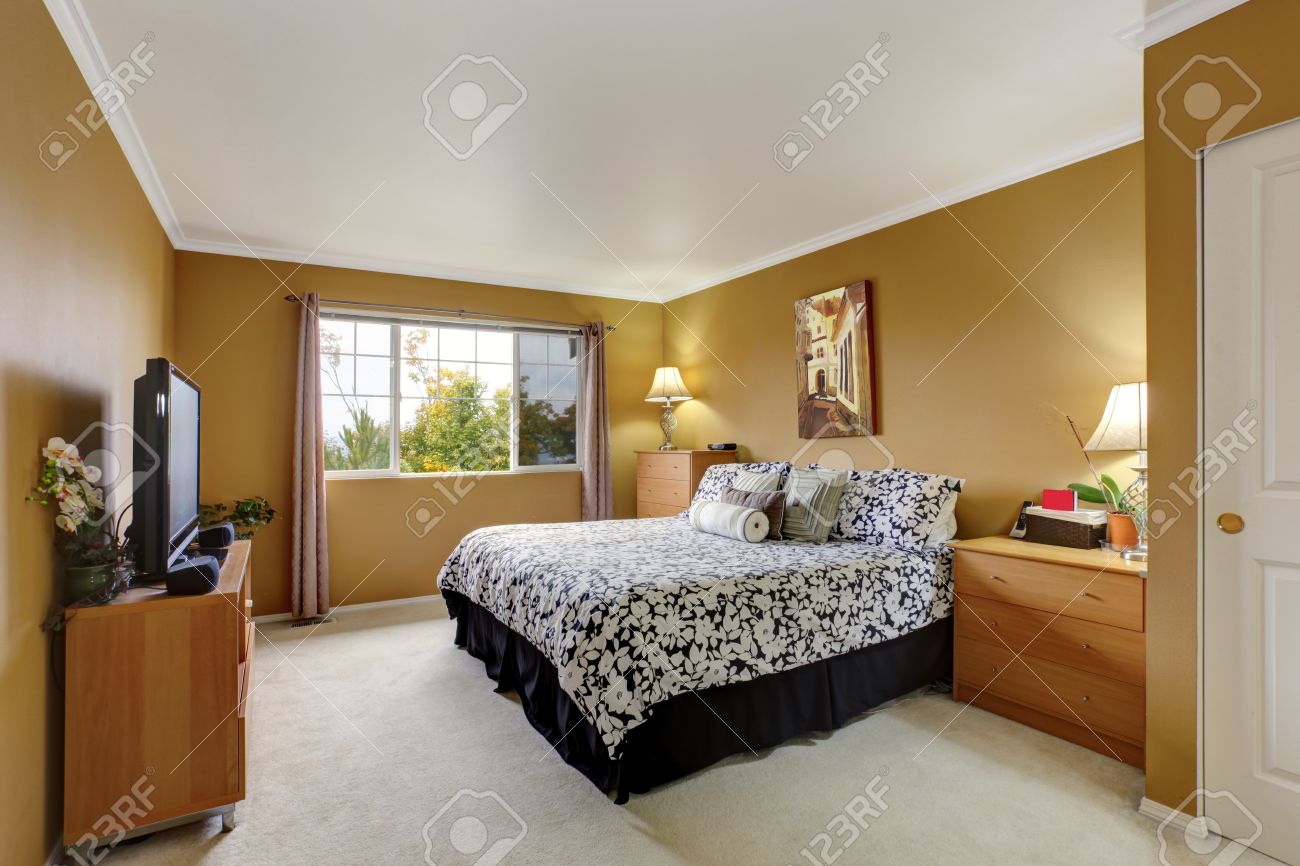 Slaapkamer in mosterd kleur met lichte ivoren vloerbedekking ...