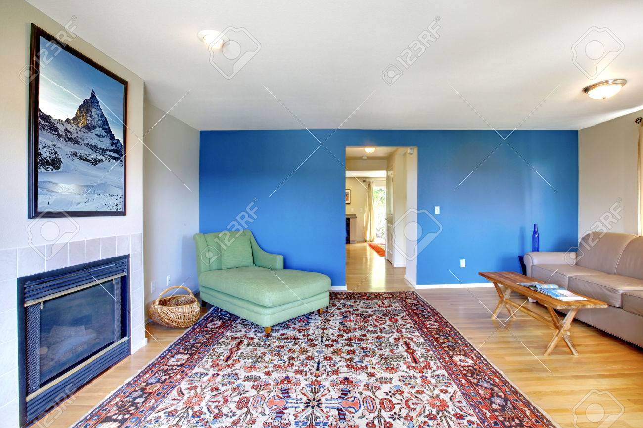 Woonkamer met helder blauw en een open haard. ingericht met groene ...
