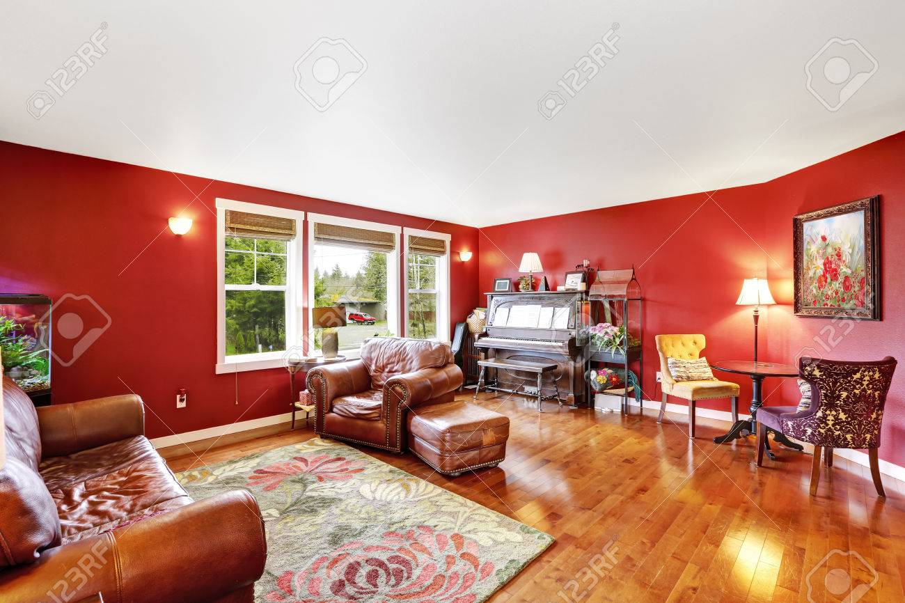 Heldere rode woonkamer interieur met bruine lederen counch ...