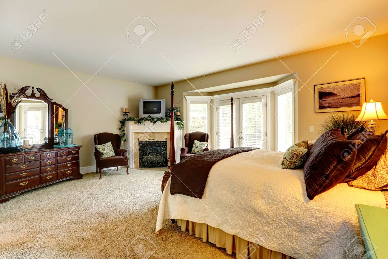 Chambre de luxe avec meuble lavabo et cheminée. vue de beau lit ...