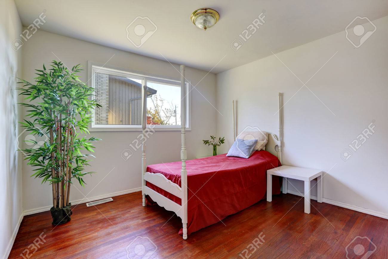 Witte slaapkamer met hardhouten vloer. uitzicht op bed met een ...