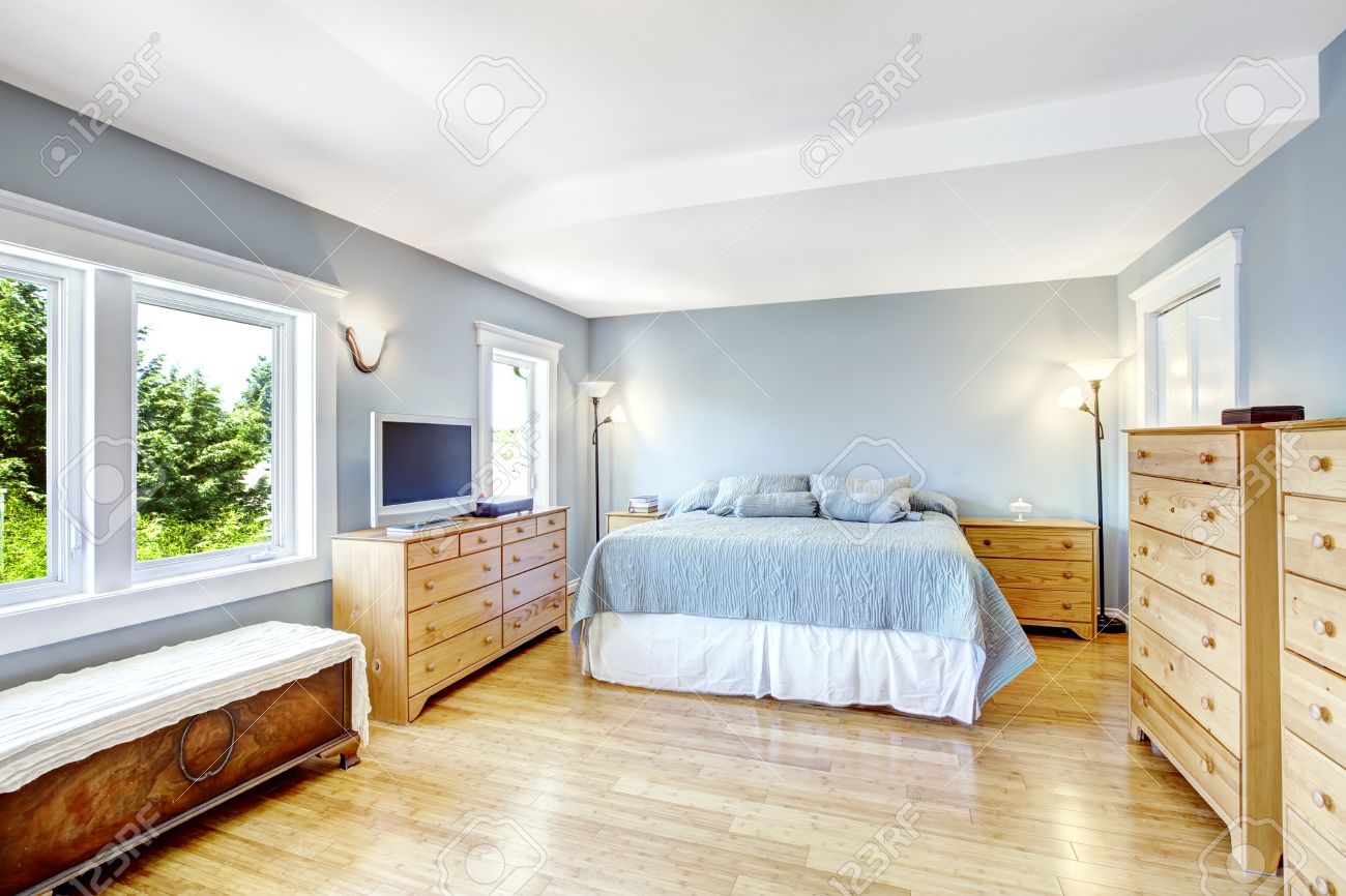 Zeer lichte slaapkamer in het licht blauw tinten met houten ...