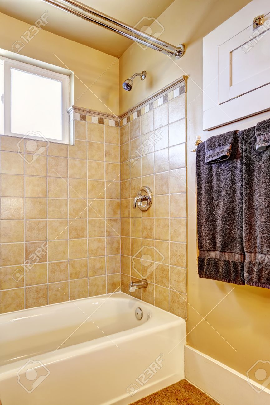 Salle de bains dans le ton jaune clair avec garniture de mur de ...