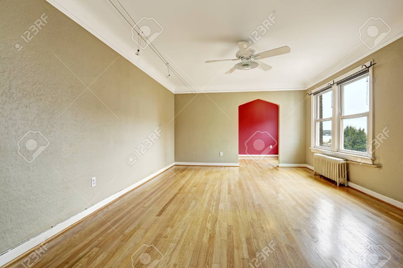 Lege woonkamer in oude appartement met hardhouten vloer, venster ...