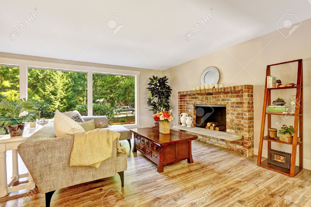 Ruime lichte woonkamer met stenen open haard, bank, houten ...