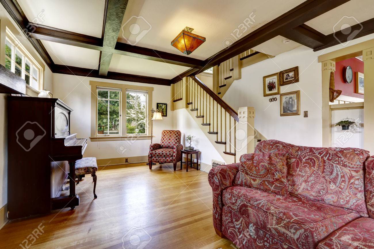 Camera familiare con pianoforte antico e divano rosso. camera con ... Scala Antica decorazione