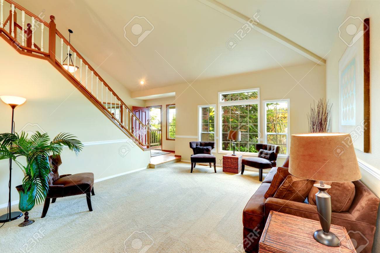 Lichte ivoor woonkamer met hoge gewelfde plafond en openslaande ...