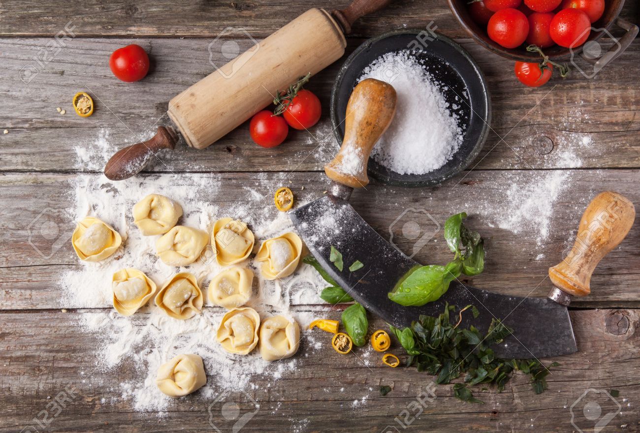 Bovenaanzicht op zelfgemaakte ravioli op oude houten tafel met ...
