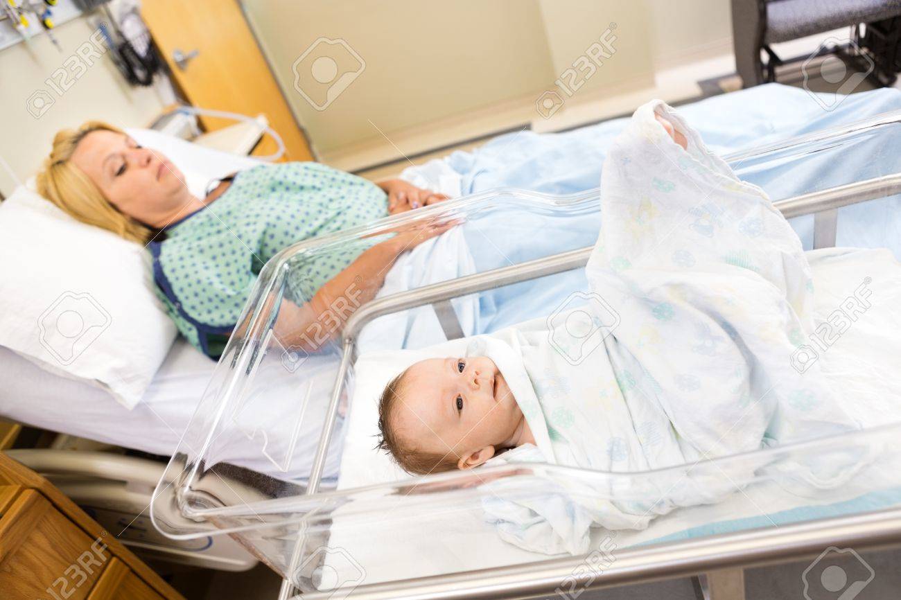 Carino babygirl neonato che giace in culla con la donna di relax ... Culla per letto
