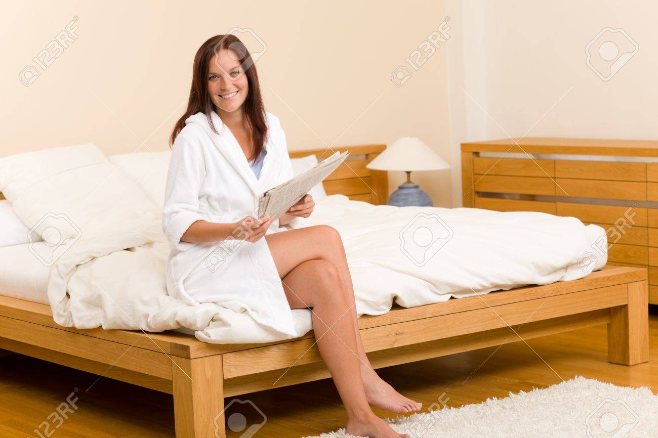 Attractive femme de lire les journaux du matin en peignoir usure ...