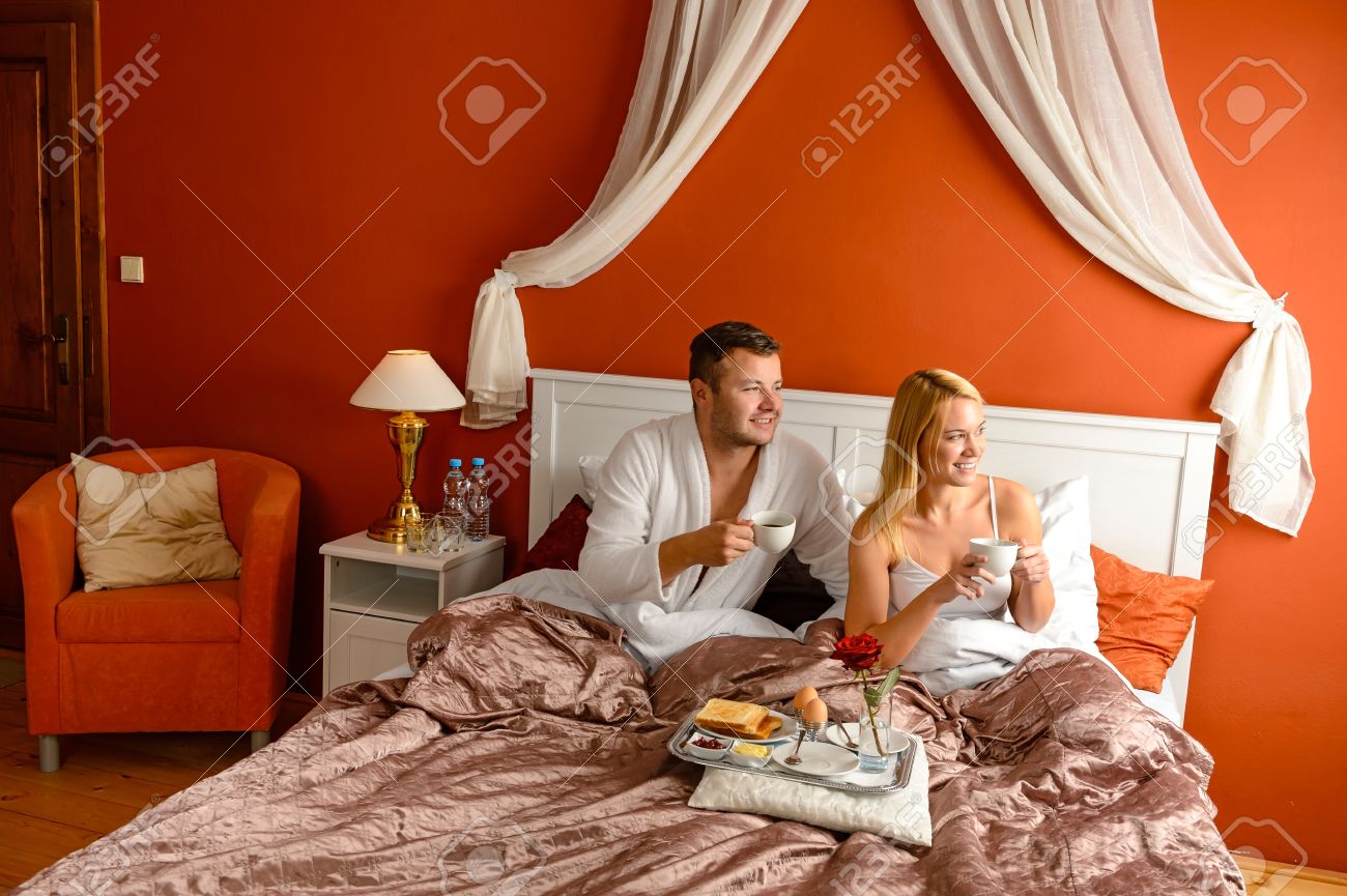 Loving paar drinken koffie in bed hotelkamer romantische ochtend ...