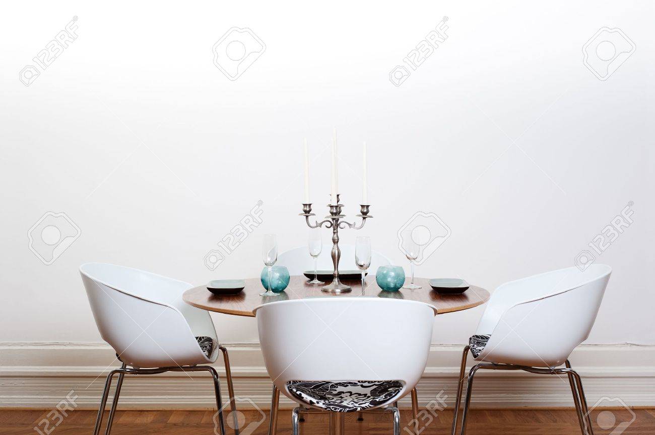 Moderne salle à manger avec une table ronde et chaises blanches et ...