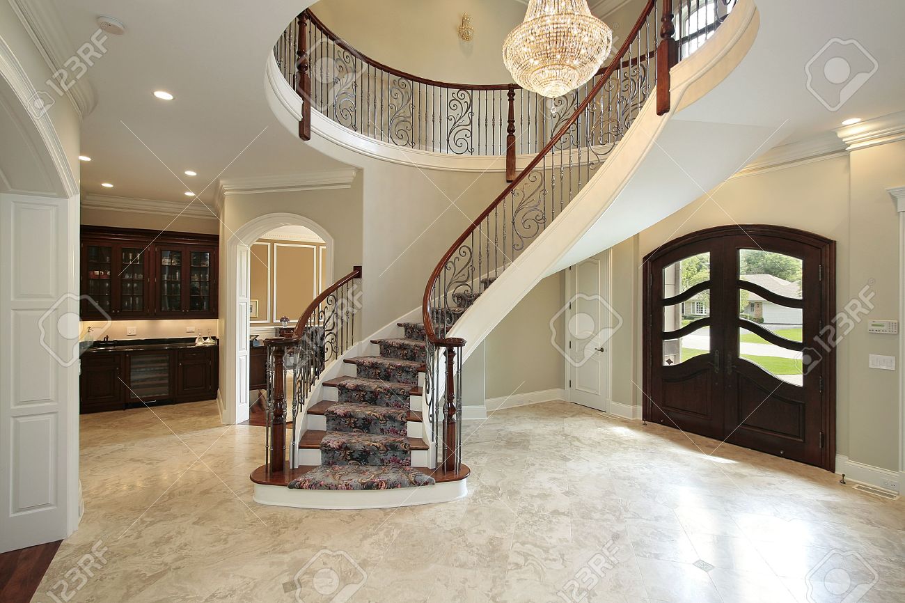Foyer in new construction home with curved staircase stock photo ...
