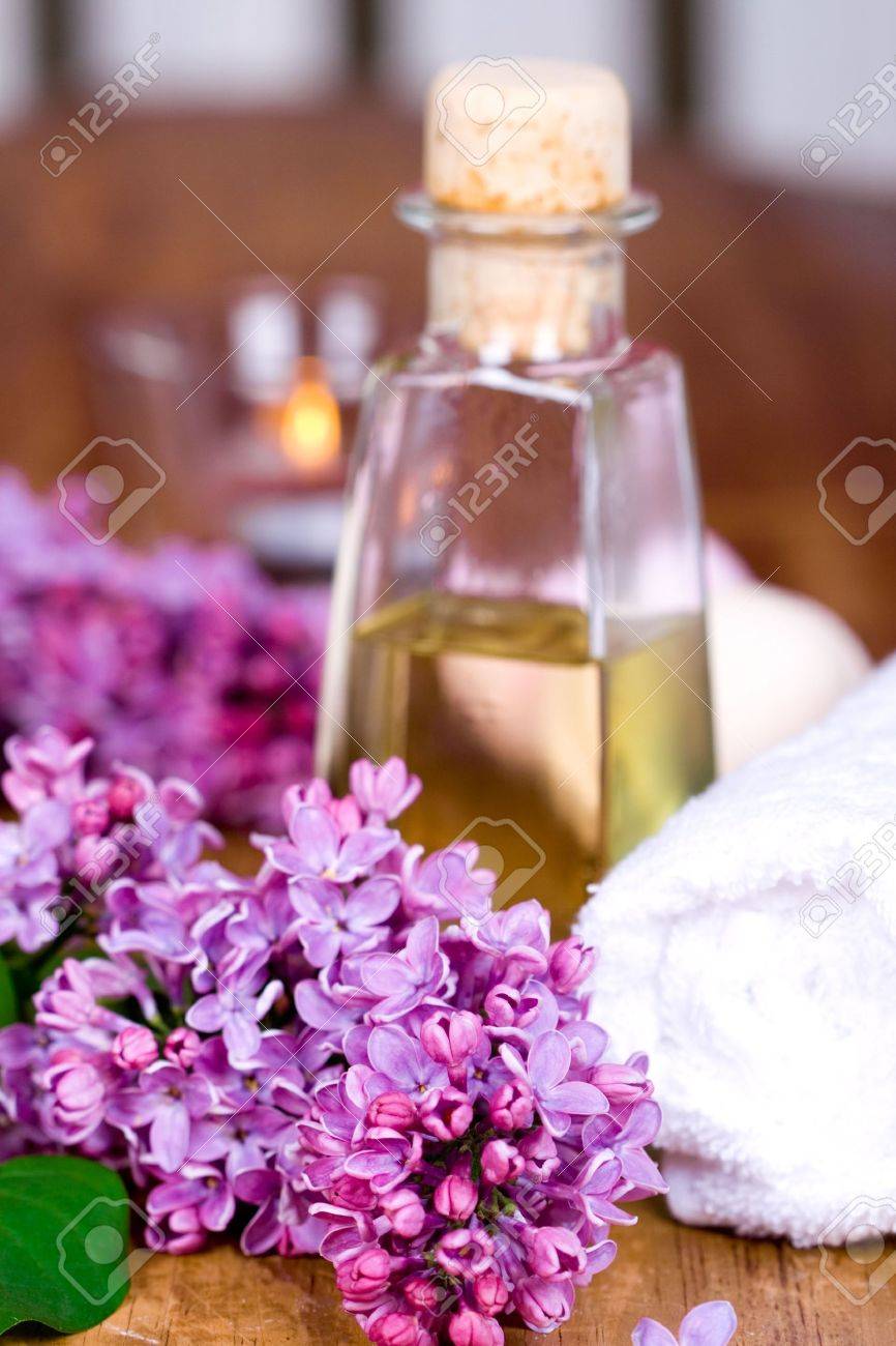 Bagno e spa elementi (asciugamano, olio, lilla, candela) su sfondo ...