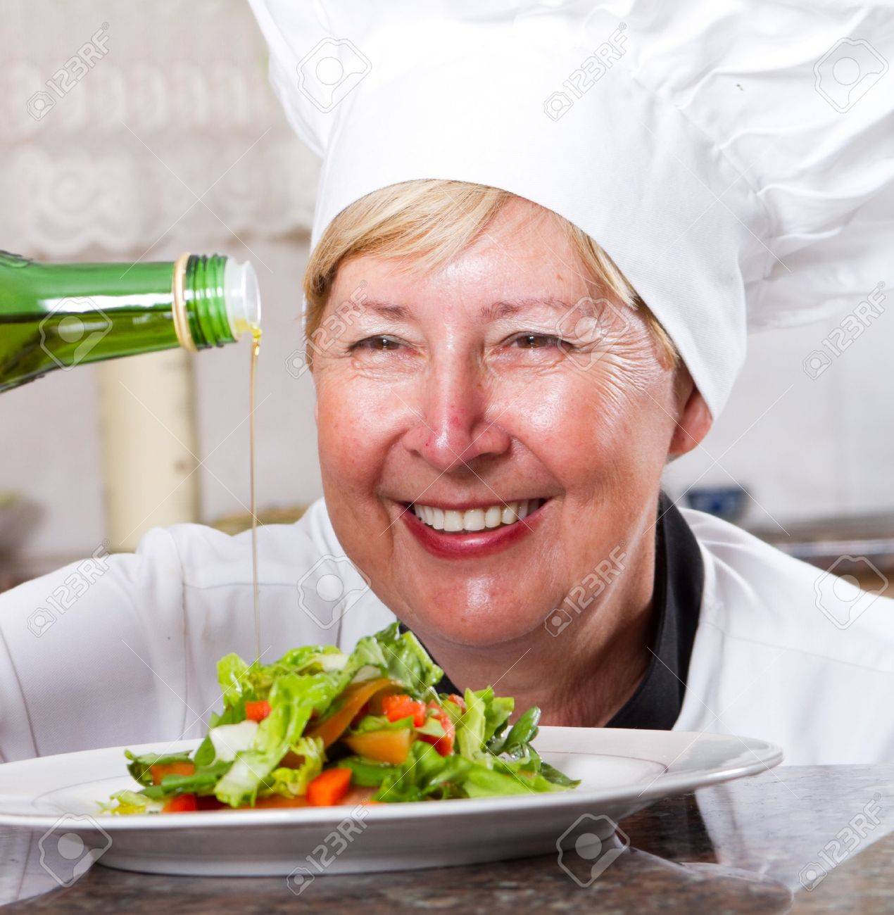 Senior chef pouring dressing onto salad stock photo, picture and ...