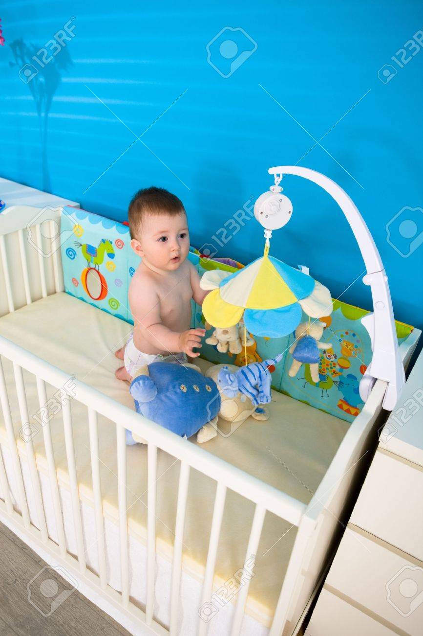 Cute baby junge (1 jahr alt) in babybett kinderzimmer, spielen ... Kinderzimmer junge