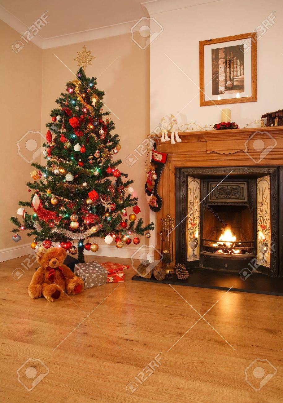 Woonkamer met kerst decoraties, een open haard en de kerst boom ...