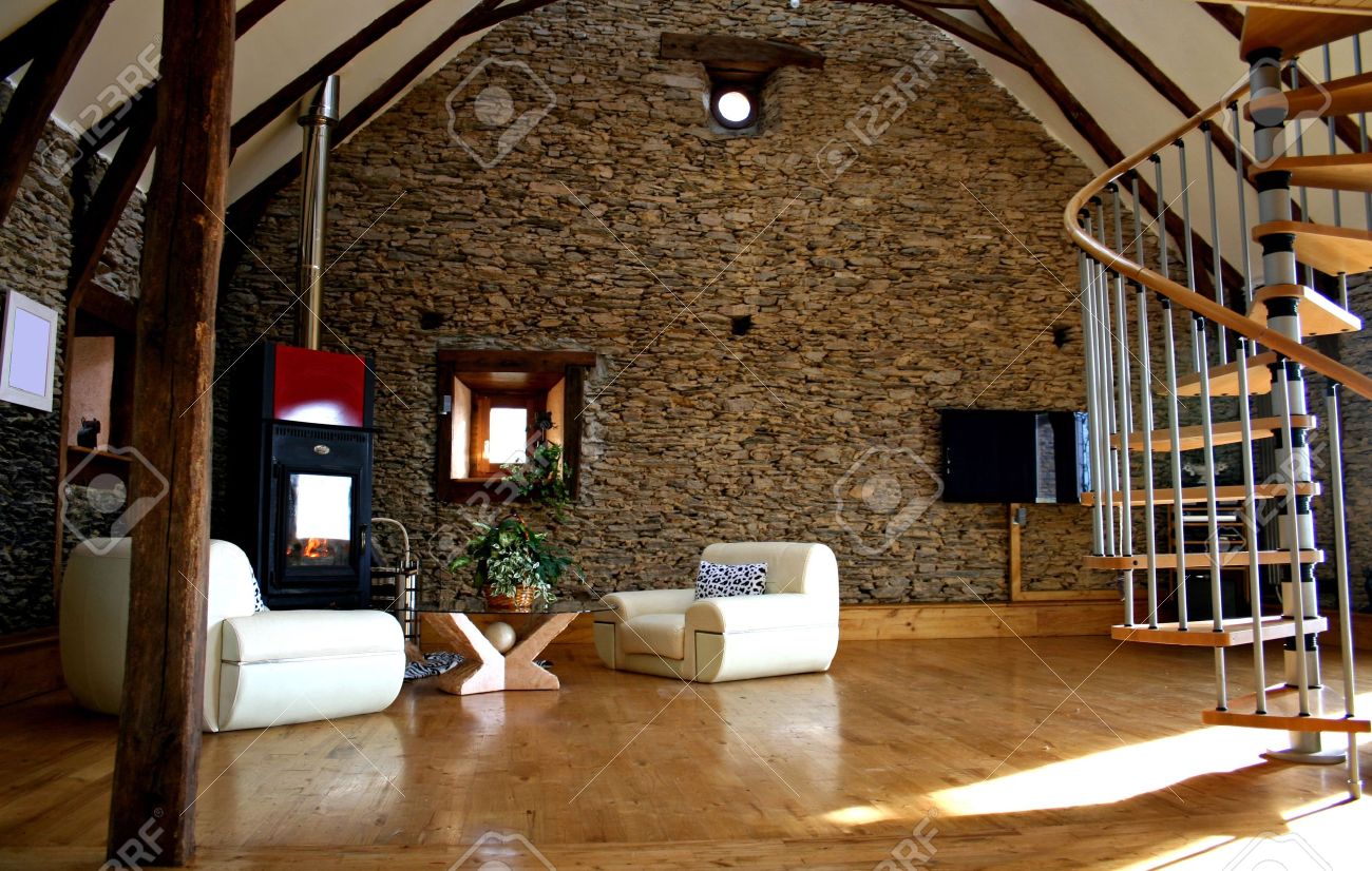 View of living room with fireplace and old stone wall and modern ...