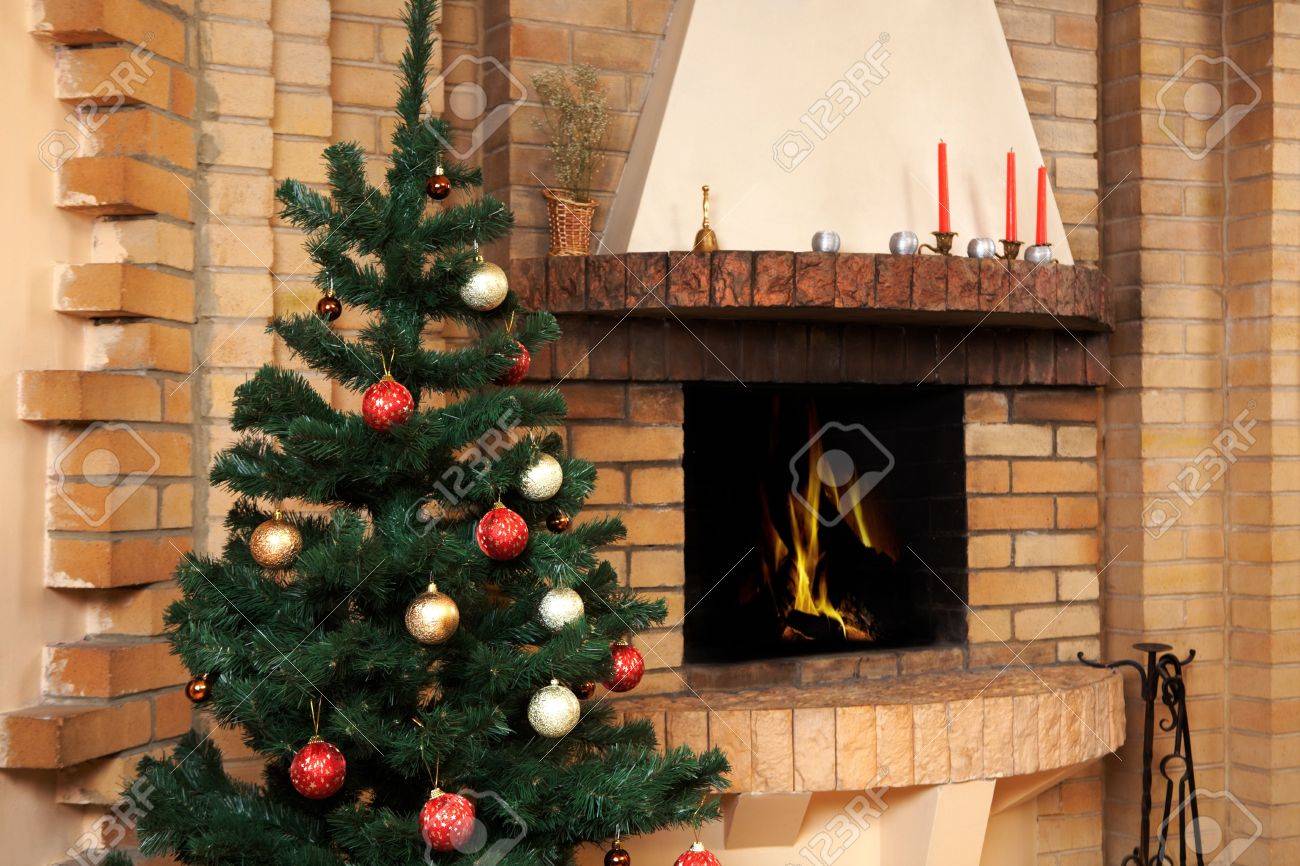 Sala con camino e abete decorato con giocattoli su di esso di ...