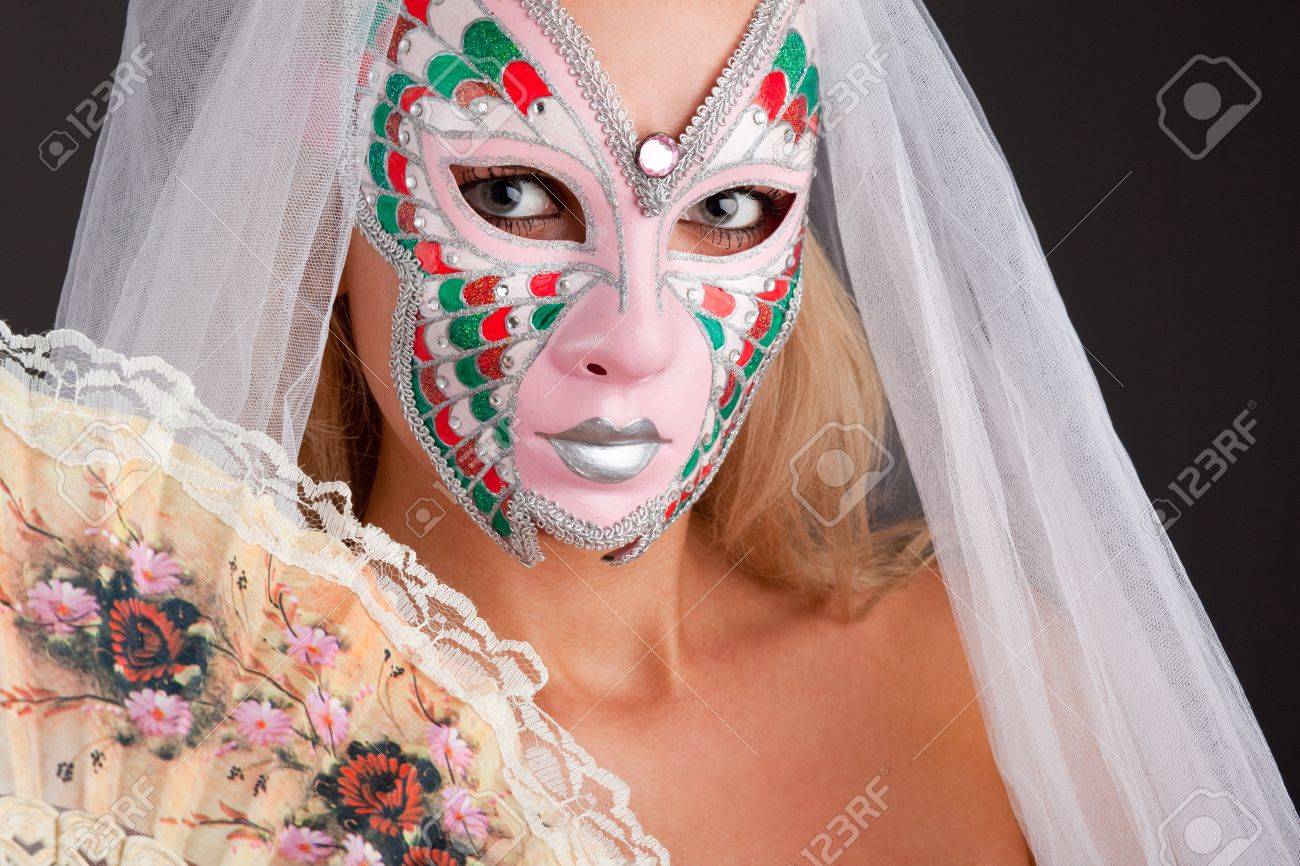 7130975 Portrait of beautiful young woman wearing carnival mask Stock Photo