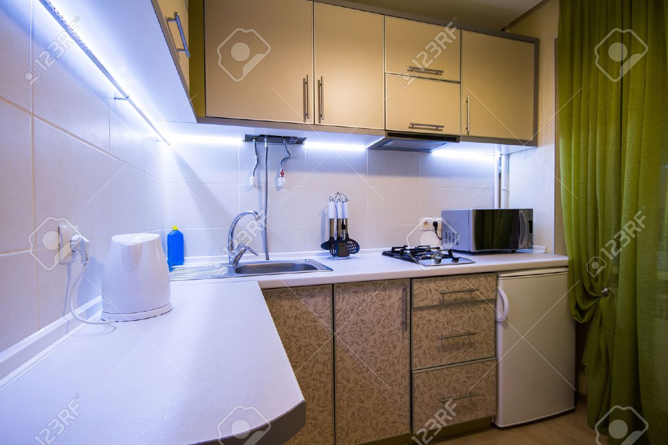 Modernt litet kök med gröna gardiner och led bakgrundsbelysning ...
