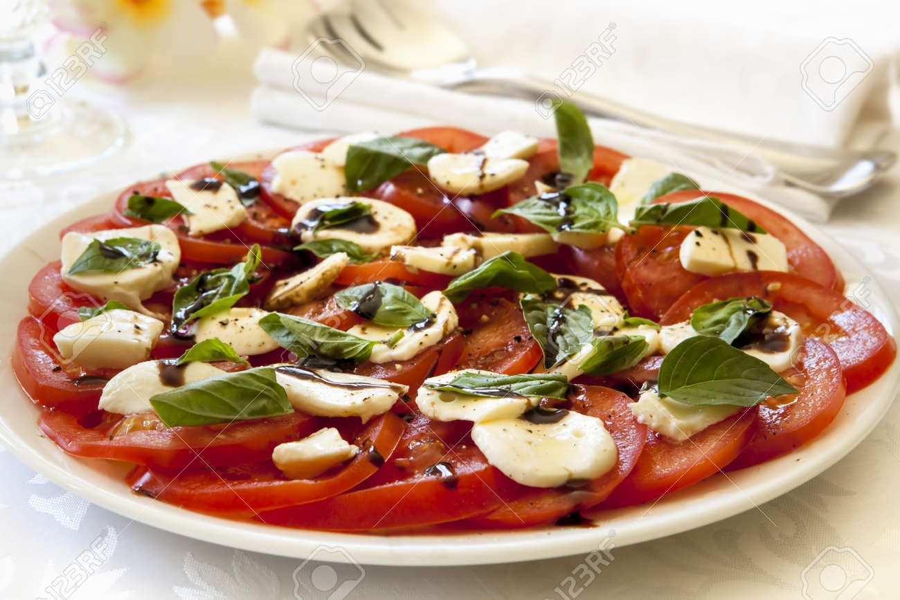 15076192-Caprese-Salat-auf-einem-Servierteller-Tomaten-mit-Baby-Mozzarella-Basilikum-und-Balsamico-Dressing-Lizenzfreie-Bilder.jpg