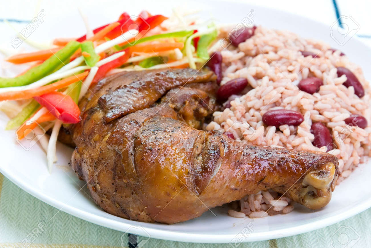 938535-Caribbean-style-jerk-chicken-served-with-rice-mixed-with-red-kidney-beans-Dish-accompanied-with-vege-Stock-Photo.jpg