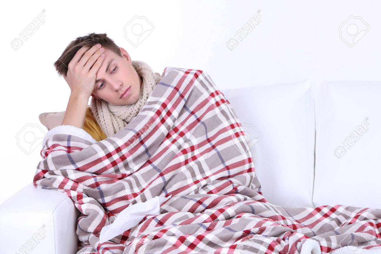 26397024-Guy-wrapped-in-plaid-sitting-on-sofa-is-ill-Stock-Photo.jpg