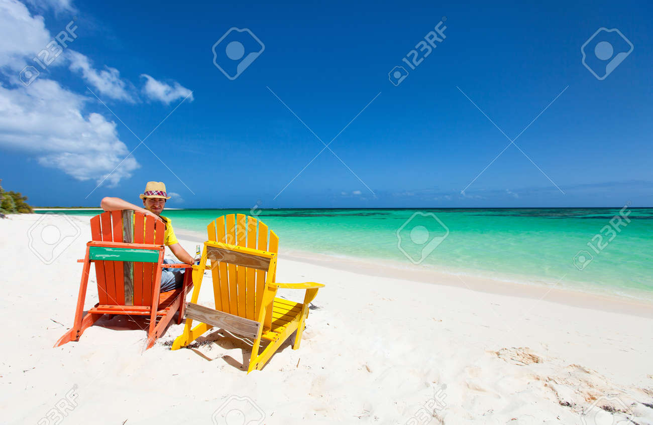 Giovane uomo godendo le vacanze in spiaggia tropicale con due ...