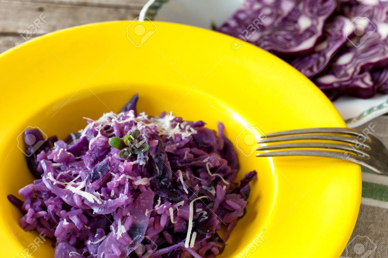 Gele plaat met paars gekleurde risotto met rode kool, traditioneel ...