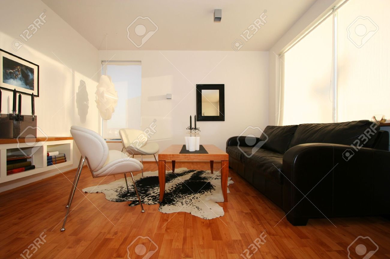 Woonkamer, met zwart lederen bankstel, spiegel op de muur, en ...