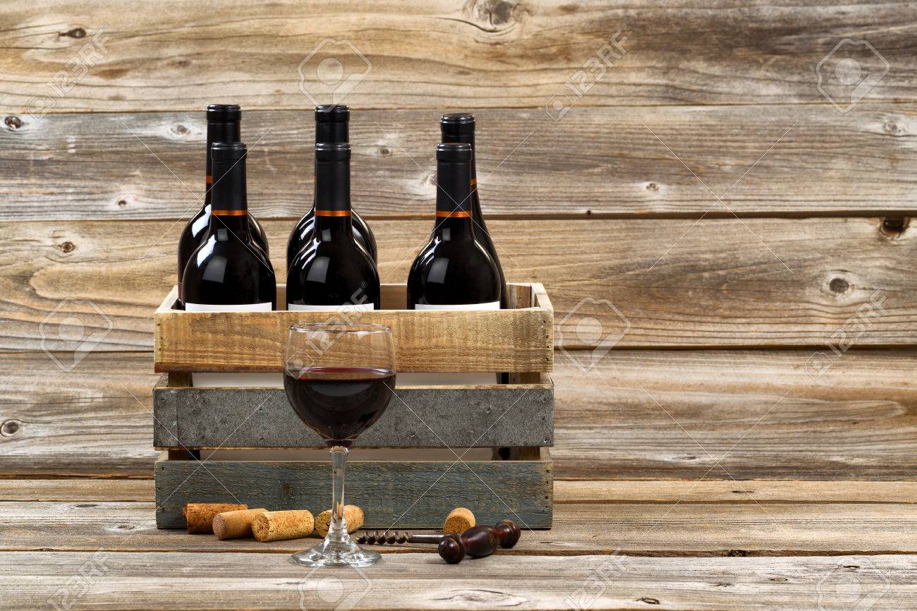 Bicchiere di vino rosso con bottiglie piene in cassa di legno ... Casse vino