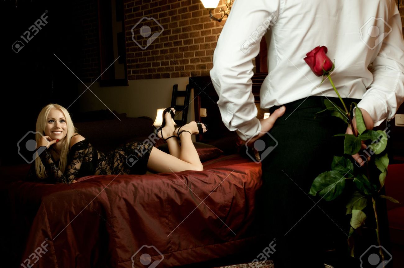 Romantische avond datum in hotelkamer, man met rode roos en sexy ...