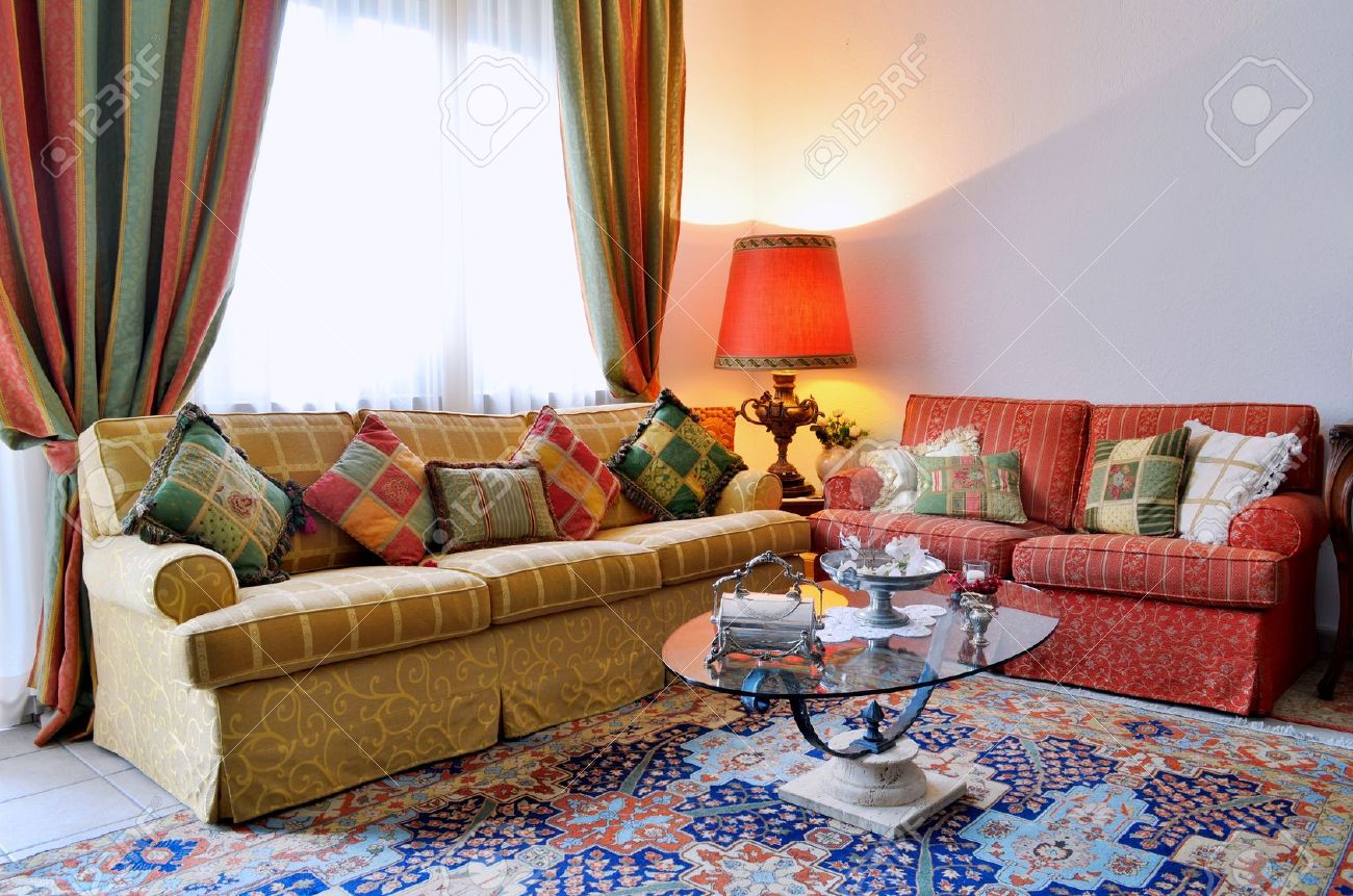 Elegante woonkamer met klassiek ogende sofa, kleurrijke gordijnen ...