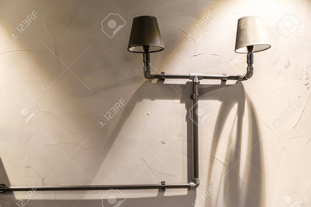 Erger verlichte grijze muur met twee retro lampenkap voor het ...