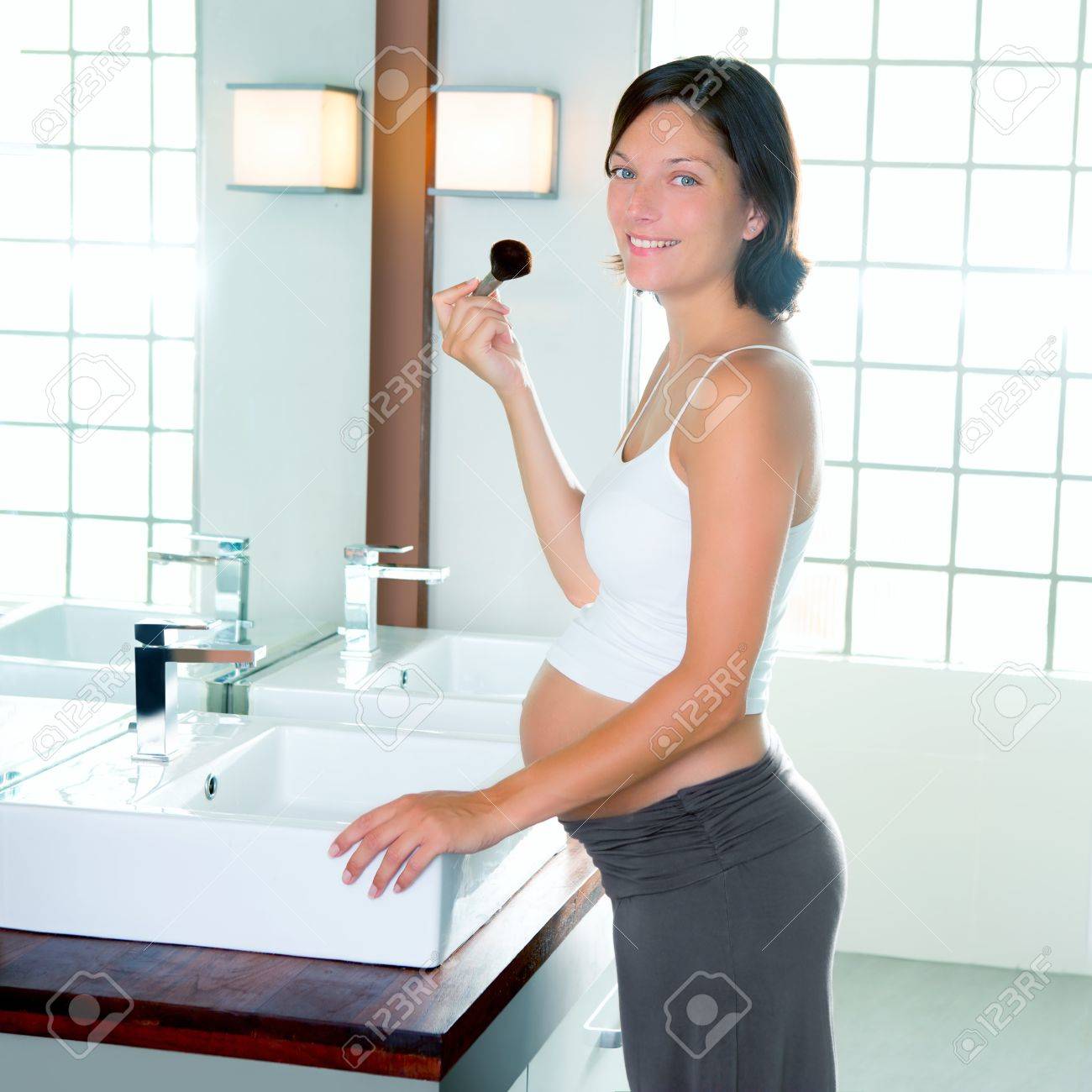 Belle femme enceinte sur le maquillage salle de bains moderne avec ...