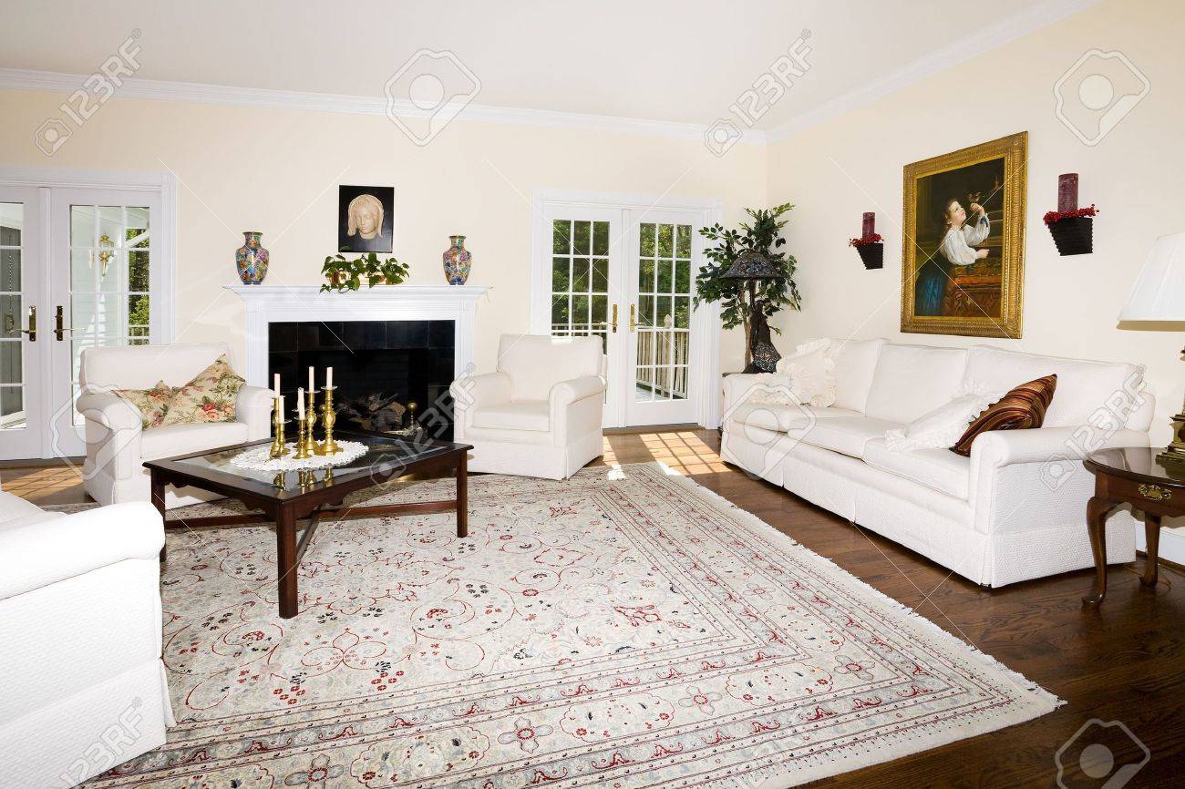 Luxe woonkamer met open haard, oosterse tapijt op de houten vloer ...