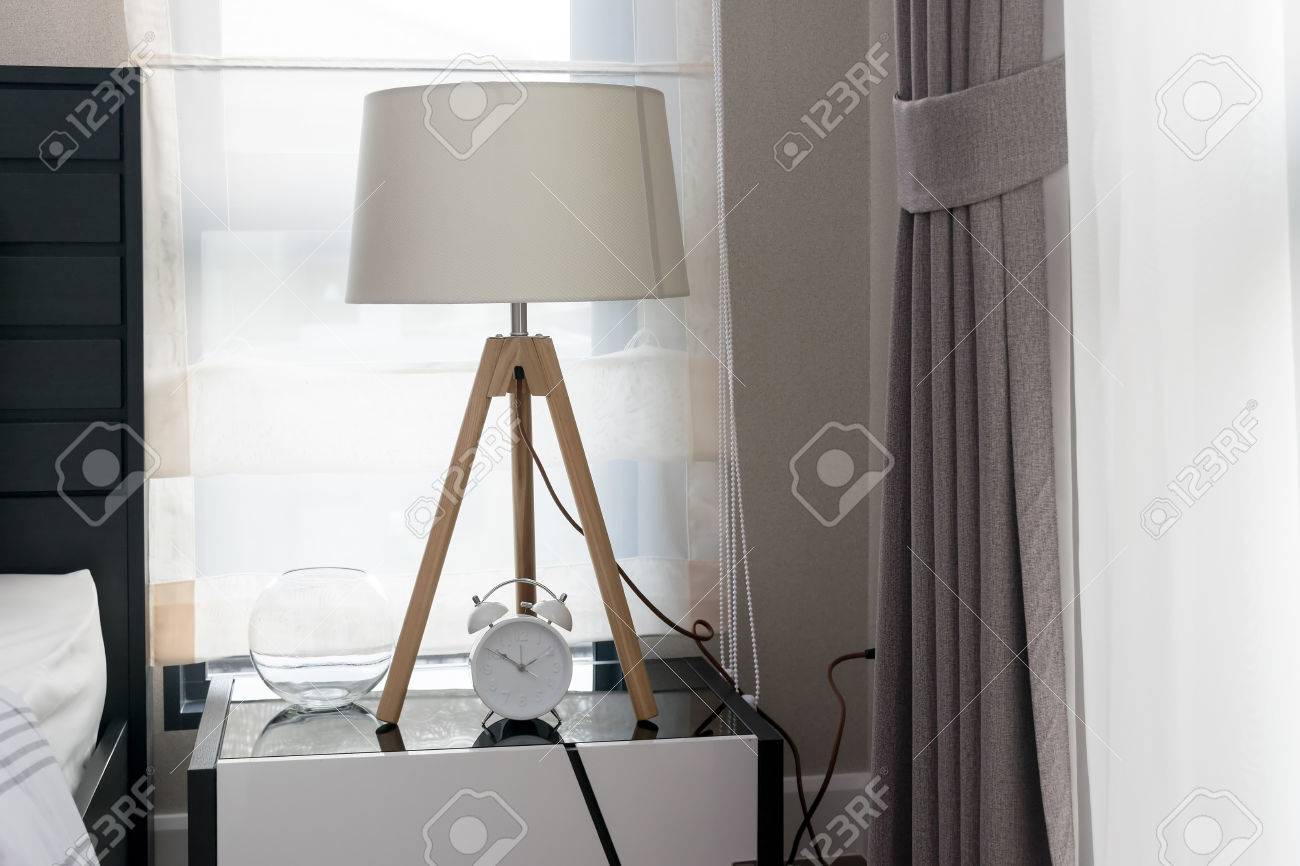 Banque dimages chambre moderne avec lampe en bois et réveil sur la table de chevet