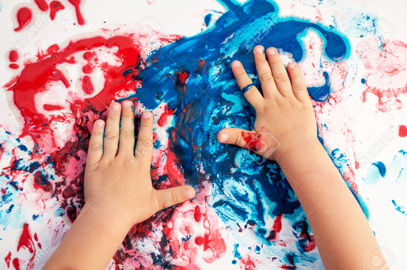 Painted hands smudging colors on messy paper . - 103156639 Painted hands smudging colors on messy paper . - 103156639