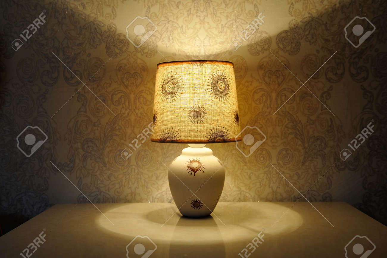 A Small Table Lamp With A Yellow Light On The Bedside Table Stock Photo Picture And Royalty Free Image Image 84329851