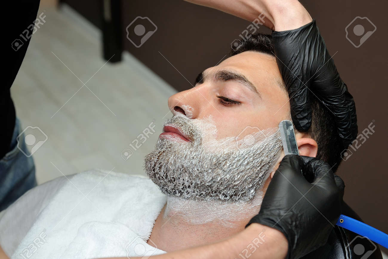 El Peluquero Afeita La Barba Del Hombre Con Una Cuchilla En Una Peluqueria De Caballeros Masculina Fotos Retratos Imagenes Y Fotografia De Archivo Libres De Derecho Image 2145