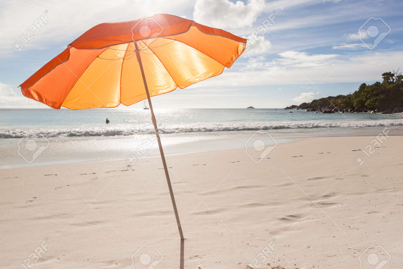 Parasol Orange Dans La Lumière Du Soleil Sur Une Plage Tropicale Le Concept De Voyage Pour Lété Les Vacances Et La Protection Solaire