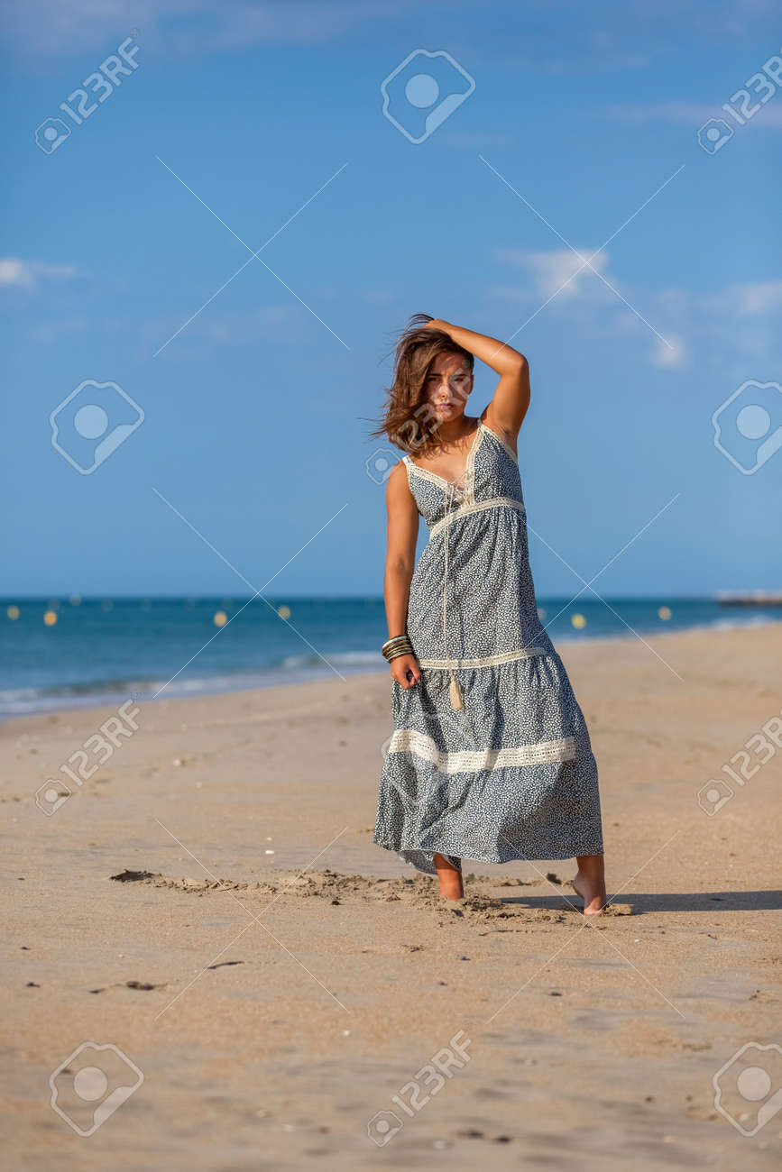 Pretty Young Woman In A Dress And Nude Foots On The Sand Of The Beach. Happy  Girl Enjoying Freedom At The Sea. Stock Photo, Picture And Royalty Free  Image. Image 145893275.