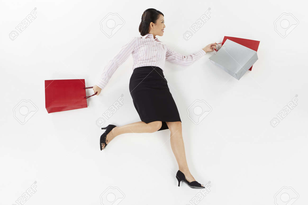 Businesswoman Posing On The Floor With Shopping Bags Stock Photo