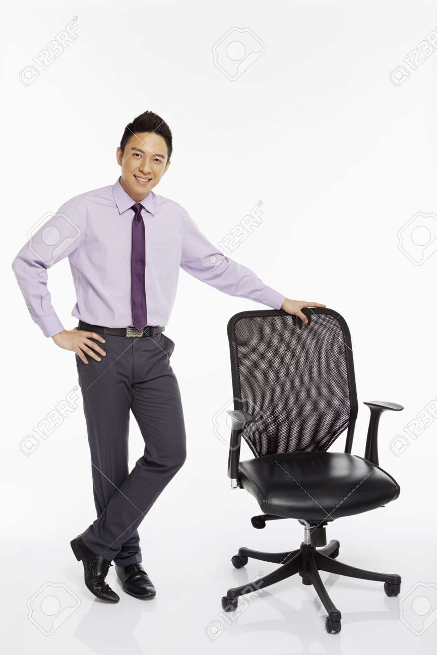 椅子の横に立っているビジネスマン の写真素材 画像素材 Image