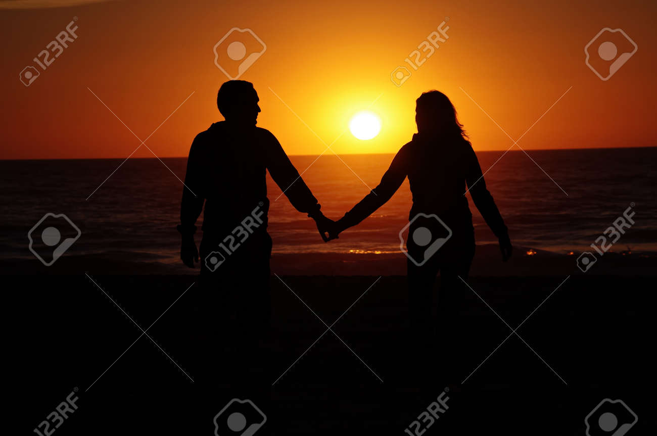夕焼けのビーチのカップル の写真素材 画像素材 Image